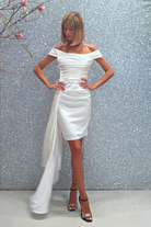 Abito corto bianco a barchetta in taffetà con strascico laterale e pieghe, firmato Moda-Mania, in tessuto elegante e femminile.