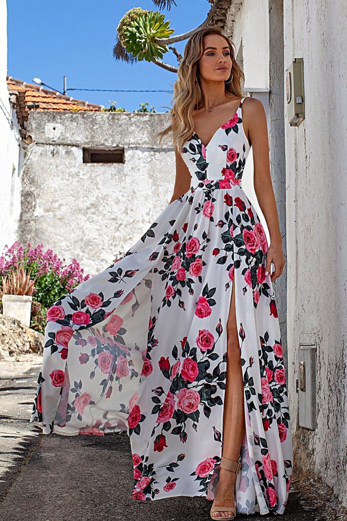 Abito lungo svasato estivo bianco con fantasia floreale fucsia e verdi, spacchi laterali, modello di Moda-Mania.