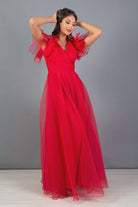 Abito lungo rosso svasato in organza di Moda-Mania con scollo a V e dettagli di volants sulle spalle.