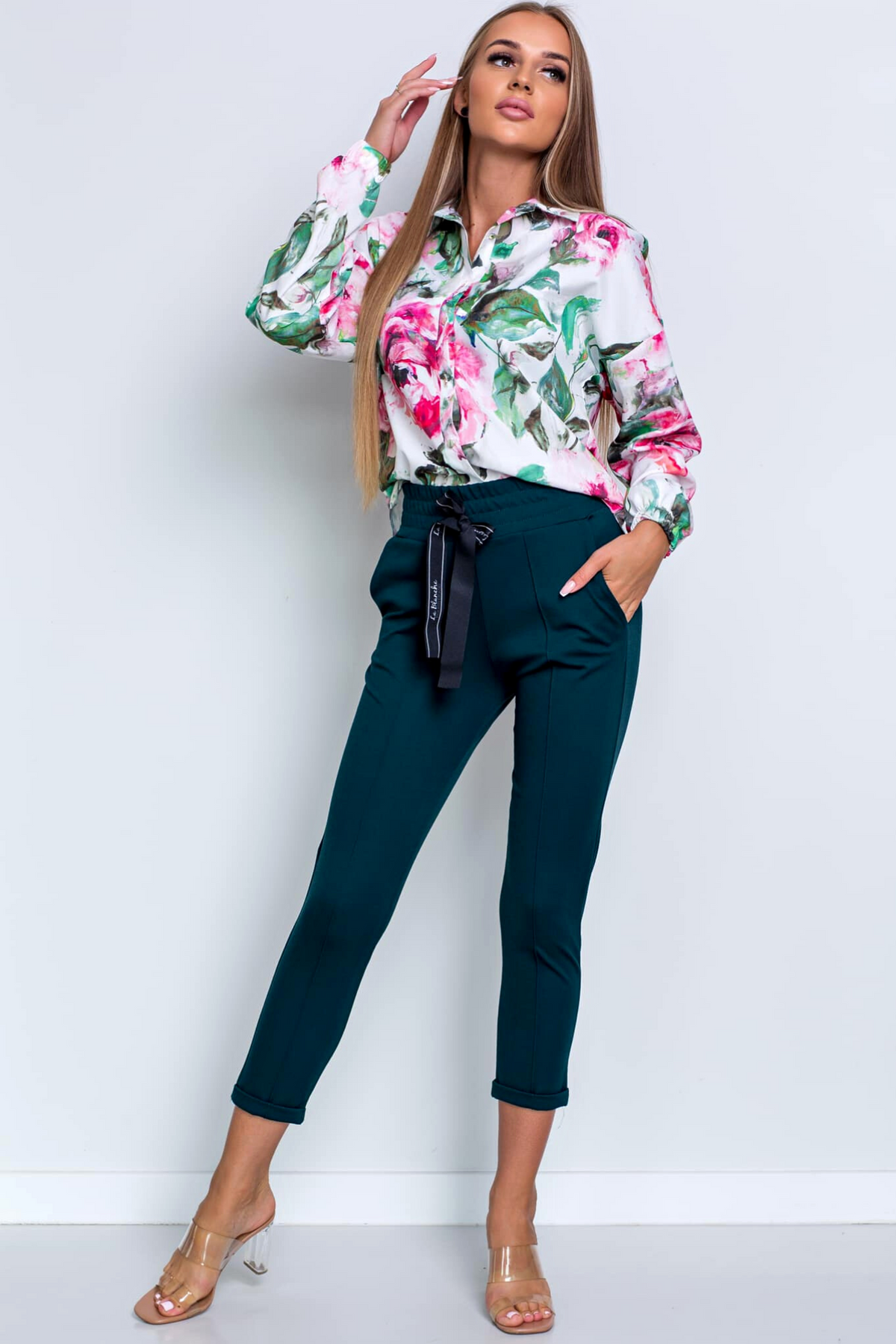 Camicia bianca a fantasia floreale con bottoni Moda-Mania, tessuto leggero e dettagli decorativi, vista frontale.