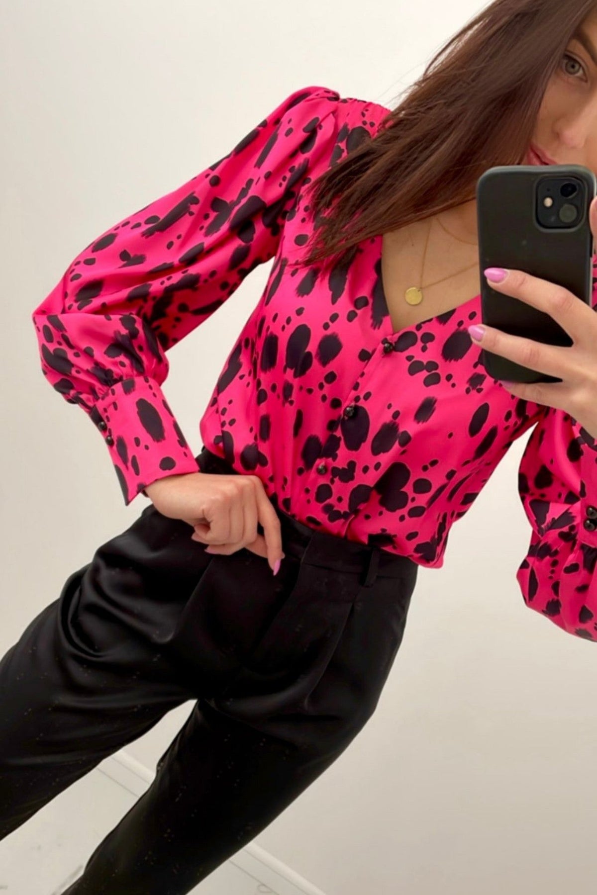 Camicia Moda-Mania fucsia a fantasia dalmata con scollo a V, maniche a sbuffo e polsini, tessuto leggero e femminile.
