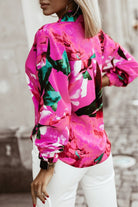 Camicia fucsia a fantasia floreale Moda-Mania con bottoni, maniche lunghe e dettaglio di bottoni decorativi visibile.