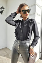 Camicia nera in viscosa Moda-Mania con collo alto, dettagli di rouches e bottoni dorati, vestibilità elegante e raffinata.