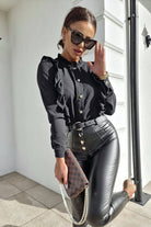 Camicia nera in viscosa Moda-Mania con collo alto, dettagli rouches e bottoni dorati, vestibilità elegante e raffinata.