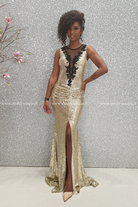 Abito lungo a sirena dorato Chanttal in paillettes con spacco centrale e ricami neri, dettaglio elegante e sofisticato.