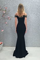 Abito lungo a sirena nero Chanttal con scollatura a barchetta e ricami floreali, in tessuto elegante.
