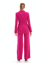 Completo tailleur fucsia magenta con giacca doppiopetto, cintura allacciabile e pantaloni larghi, moda moderna e versatile.