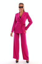 Completo tailleur fucsia magenta con giacca doppiopetto, cintura allacciabile e pantaloni larghi, firmato Moda-Mania.