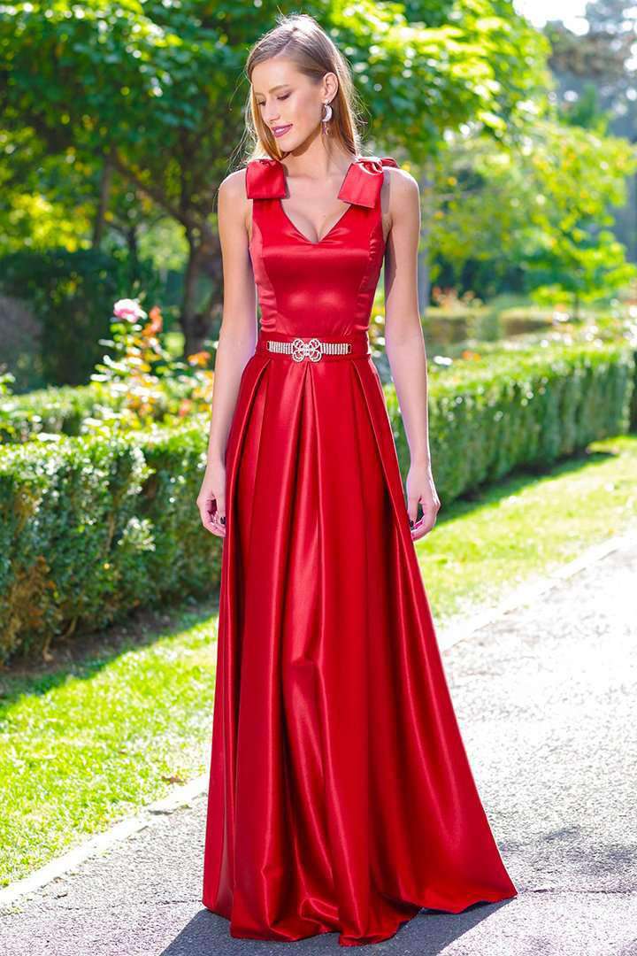 Abito lungo svasato rosso Artista con corpino, fiocchi sulle spalle e cordoncino, tessuto fluido e dettagli eleganti.
