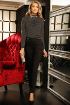 Blusa elegante Fofy in velo nero con piccola fantasia a pois, dettaglio di jabout e accessorio gioiello, stile raffinato.