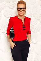 Camicia rossa Fofy con alamari e passamaneria nera, rifiniture nere, tessuto leggero e dettagli eleganti.