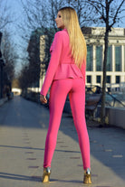 Completo tailleur Foggi fucsia con giacca doppio petto con balza in vita e pantaloni aderenti, abbigliamento elegante femminile.