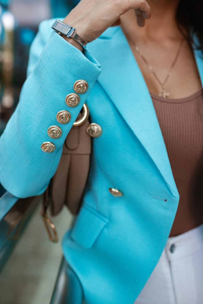 Giacca doppiopetto azzurro internamente foderata accessoriata con bottoni decorativi dorati