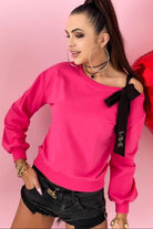 Maglia fucsia in cotone a manica lunga con fiocco nero decorativo su una spalla, stile denim e sportivo di Moda-Mania.