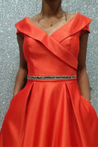 Abito svasato rosso in taffetà Moda Mania con coda, scollatura a V e tasche laterali, vestito elegante e femminile.
