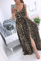 Abito lungo svasato estivo Moda-Mania a fantasia leopardata nera con spacchi laterali, tessuto leggero e stile elegante.