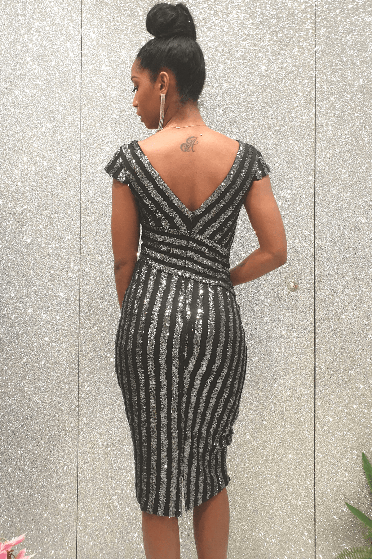 Abito a tubino Moda Mania nero con fantasia righe in paillettes argento, maniche tre quarti e scollo a V profondo.