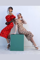 Abito aderente midi rosso con fantasia pois neri, corpetto a fascia e maniche lunghe, firmato Moda-Mania.