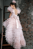 Abito rosa per bimba Moda-Mania con maniche a ventaglio, gonna in tulle multi volants e strascico staccabile.