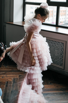 Abito rosa per bimba Moda-Mania con maniche a ventaglio, gonna in tulle multivolants e strascico staccabile.