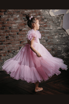 Abito per bambina rosa di Moda-Mania con maniche a ventaglio, gonna in tulle multistrato e dettagli di volants.