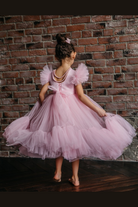 Abito per bambina rosa di Moda-Mania con maniche a ventaglio e gonna in tulle multistrato con volant, dettaglio elegante.