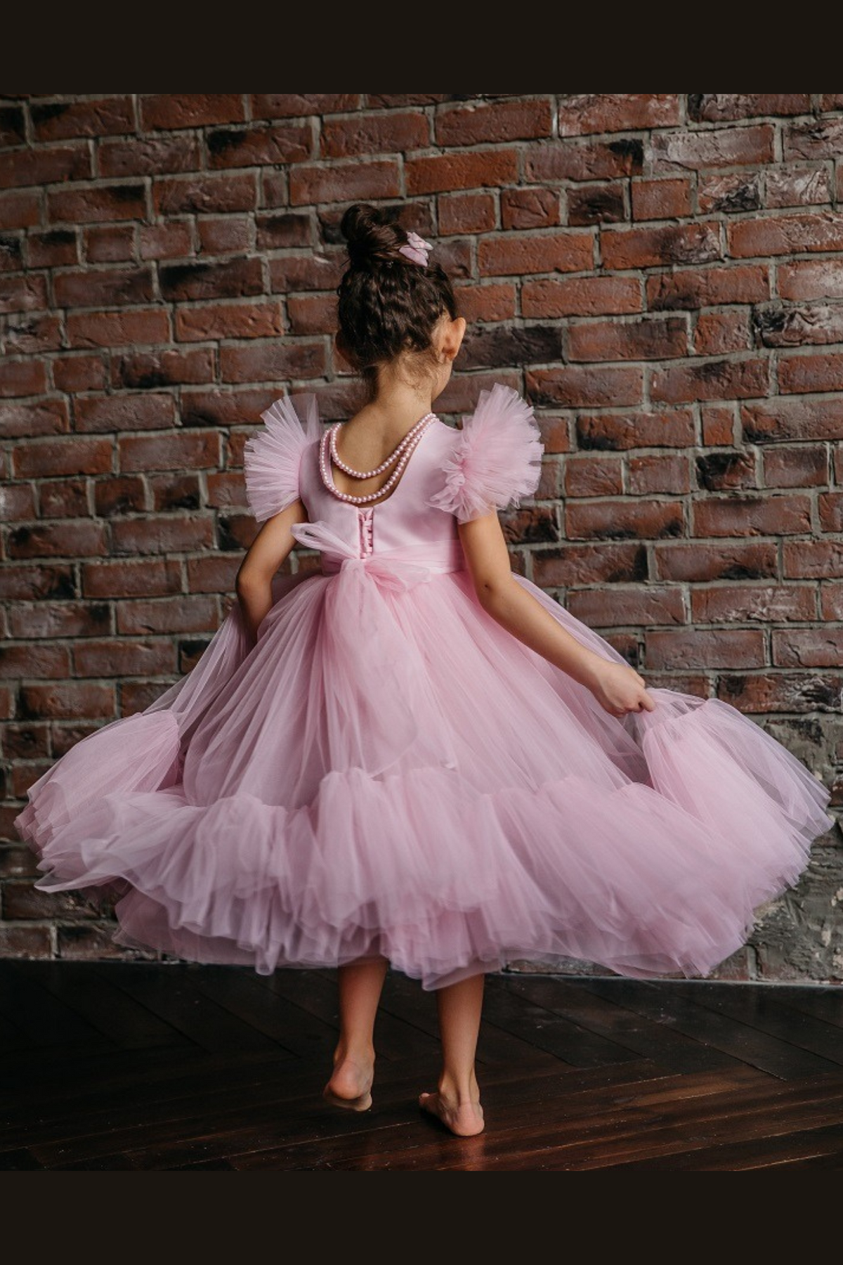 Abito per bambina rosa di Moda-Mania con maniche a ventaglio e gonna in tulle multistrato con volant, dettaglio elegante.