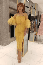 Abito midi aderente giallo senape in pizzo con maniche a campana in tulle e cintura, da Moda-Mania, stile elegante e femminile.