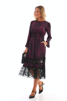Abito midi svasato nero con fantasia magenta e inserto in tulle floreale, firmato Moda-Mania, visibile in dettaglio.