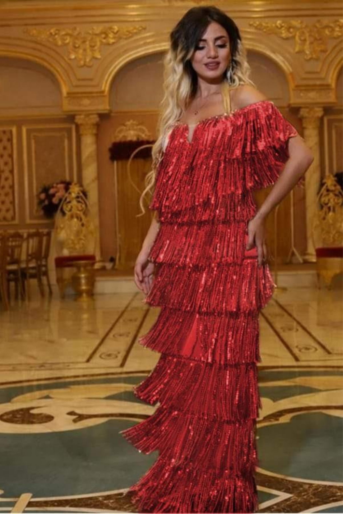 Abito lungo rosso Moda Mania con frange decorative in paillettes e scollo a barchetta, dettagli eleganti e sofisticati.