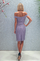 Abito corto lilla in merletto floreale con applicazioni di strass e scollo a barchetta, marca Moda-Mania, dettaglio elegante e femminile.
