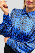 Camicia elegante Moda-Mania a fantasia leopardata blu con maniche a sbuffo e bottoni gioiello, dettaglio di stile raffinato.