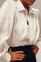 Camicia elegante bianca Moda-Mania in tessuto satinato con maniche a sbuffo e bottoni gioiello.