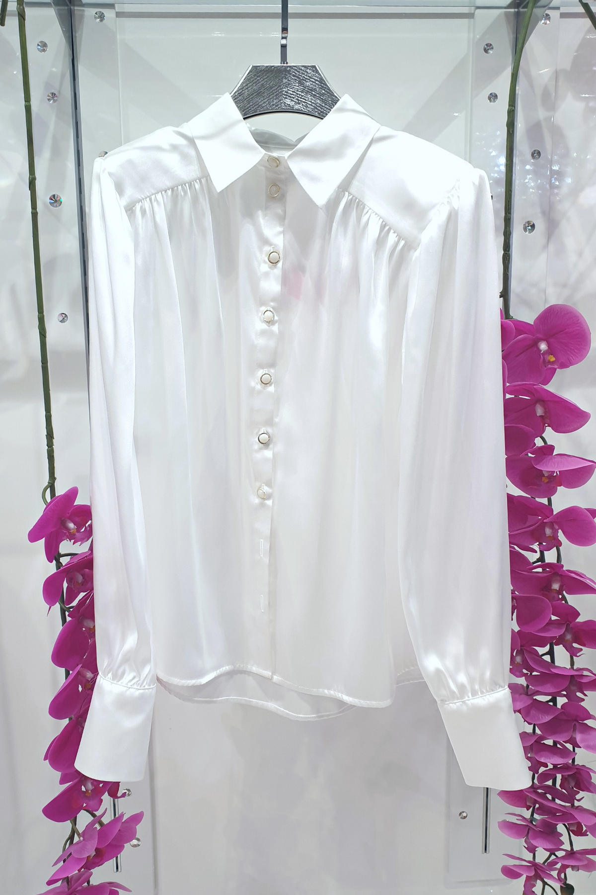 Camicia bianca elegante Moda-Mania in tessuto satinato con maniche a sbuffo e bottoni gioiello, dettaglio frontale.