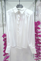 Camicia bianca elegante Moda-Mania in tessuto satinato con maniche a sbuffo e bottoni gioiello, dettaglio frontale.