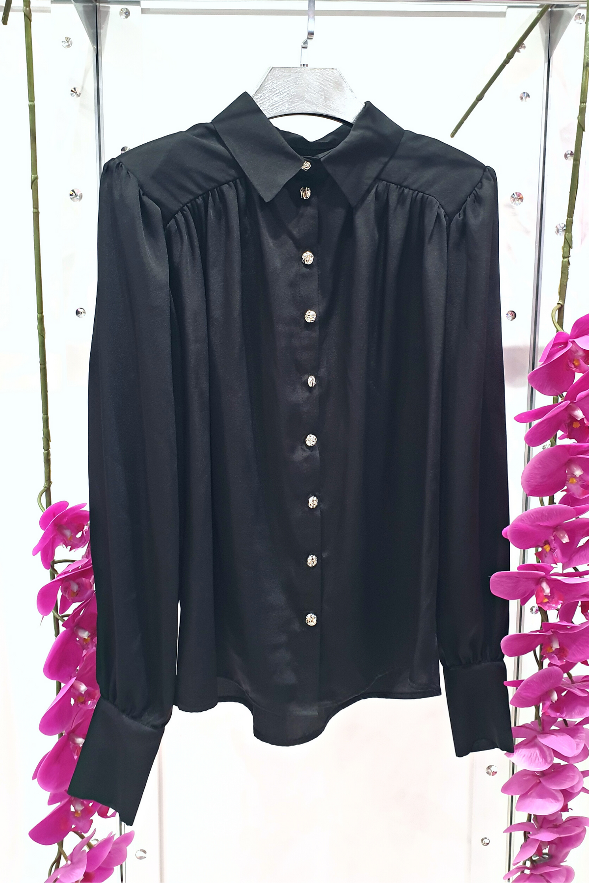 Camicia elegante nera Moda-Mania in tessuto satinato con maniche a sbuffo e bottoni gioiello bianchi, dettaglio frontale.