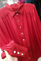 Camicia elegante rossa Moda-Mania in satinato con maniche a sbuffo e bottoni gioiello bianchi, dettaglio tessuto e design femminile