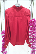 Camicia elegante rossa Moda-Mania in tessuto satinato con maniche a sbuffo e bottoni gioiello bianchi, dettagli raffinati.