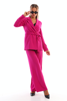 Completo tailleur fucsia magenta di Moda-Mania con giacca doppiopetto con cintura e pantaloni larghi, stile elegante e moderno