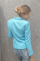Giacca da tailleur doppiopetto azzurro Moda-Mania con fodera interna e bottoni decorativi dorati, stile elegante e sofisticato.