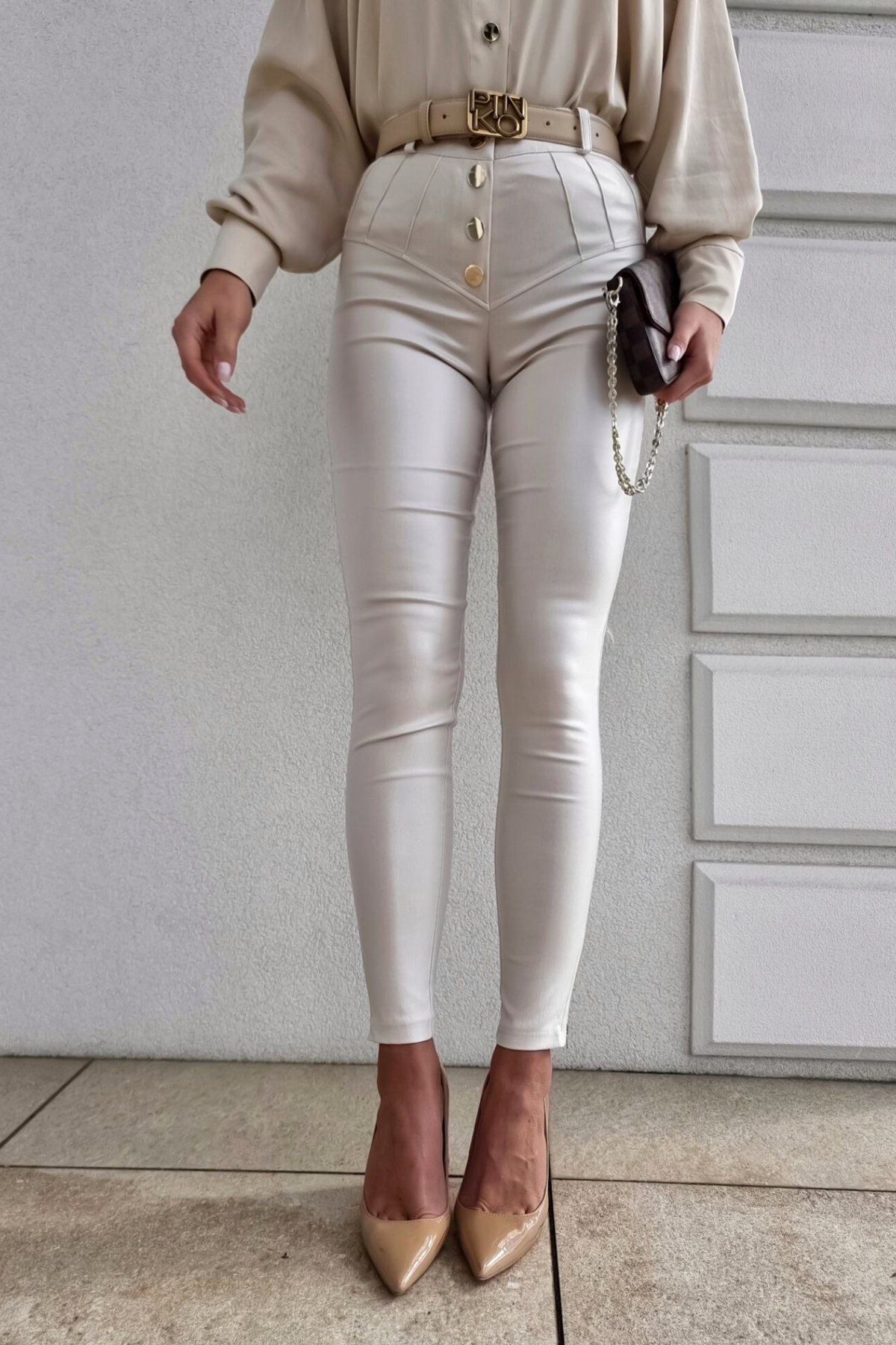 Pantaloni in similpelle color panna a vita alta con bottoni e cerniere, marca Moda-Mania, dettaglio di stile e accessori.